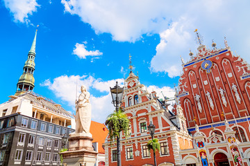 View of the Old Town square, Roland Statue, The Blackheads House and St Peters Cathedral against blue sky in Riga, Latvia. Summer sunny day