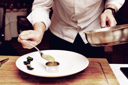 Chef is putting puree to plate, toned