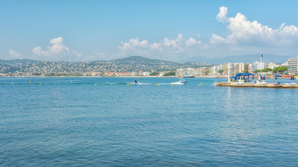 Fototapeta premium Woman water skiing in the Golfe Juan with in the background the hotels of the French city of Juan-les-Pins