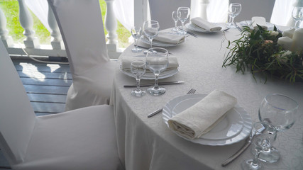 Banquet decorated table, with cutlery. Wedding decor in the banquet hall.Serving of a festive table, plate, napkin, knife, fork. Table setting decoration. Romantic Dinner or other events.