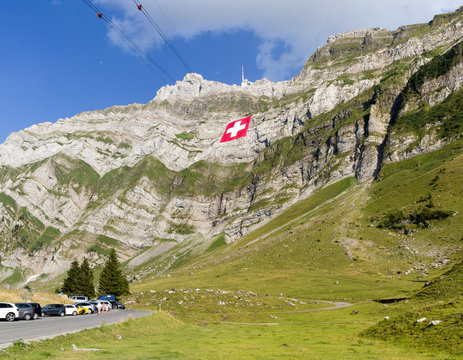 Schwaegalp, Switzerland: 31.07.2018 - Huge Swiss national flag (80mx80m, 700 kg), which is the biggest Swiss flag in the world) hangs on the Saentis mountain on National Day