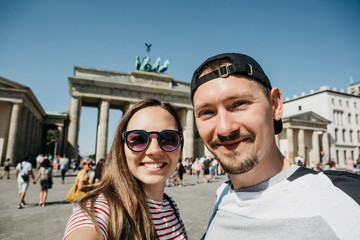 Young beautiful couple making selfie against the background of the Brandenburg Gate in Berlin in...