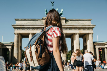 A tourist or a student with a backpack in Berlin in Germany visits the sights. Ahead is the...
