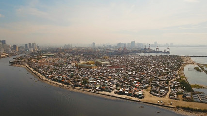 Aerial view poor district of Manila slums, ghettos, wooden old houses, shacks. Slum area of Manila, Philippines. Manila suburb, view from the plane.