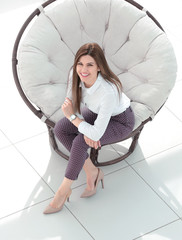 top view.young woman sitting in soft round chair