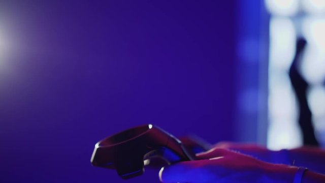 Side view closeup of VR controllers in the hands of men
