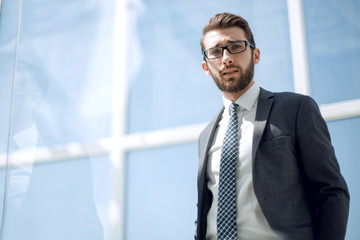 young businessman standing near the office window