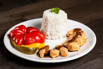 Chinese meal with rice, paprika and chicken on a white plate