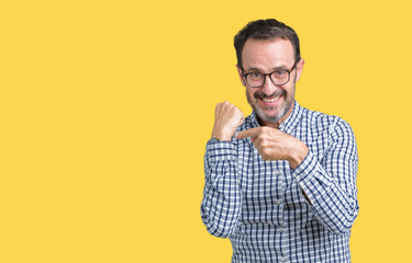 Handsome middle age elegant senior man wearing glasses over isolated background In hurry pointing to watch time, impatience, upset and angry for deadline delay