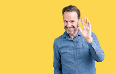 Handsome middle age elegant senior man over isolated background Waiving saying hello happy and smiling, friendly welcome gesture © Krakenimages.com