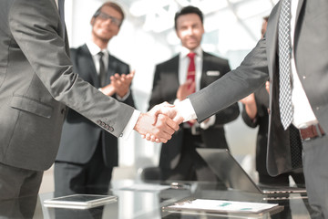 handshake of financial partners in the office