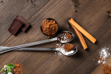Long spoons on dark wood, cocoa and chocolate composition