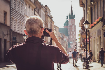 13.07.2018 Krakow, Poland: tourist travel photographer taking photo of the street with dslr camera,...