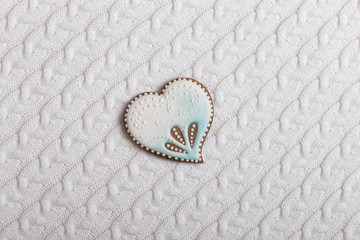 painted blue and white gingerbread in the shape of a heart on a white background from knitted knitwear