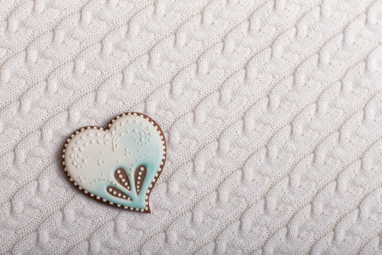 painted blue and white gingerbread in the shape of a heart on a white background from knitted knitwear