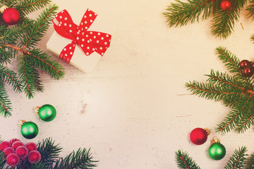 Fototapeta na wymiar Christmas gift giving flat lay scene - christmas present box in white box on white wooden table background, retro toned