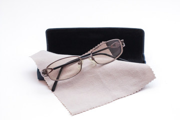 Tinted glasses and case with glasses cleaning cloth on white background