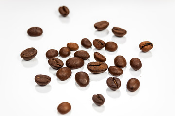 Obraz premium Coffe beans isolated on reflective white surface