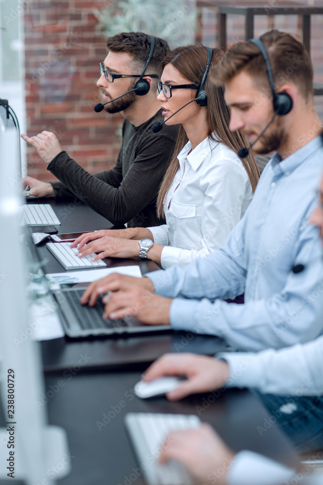 Wall mural close up.call center operators sitting at the desk.