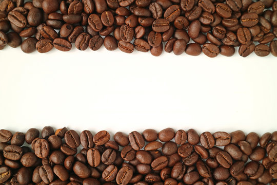 Heap of roasted coffee beans on white background, top view with free space for text or design