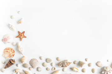 Concept on the marine theme. Seashells, towel on a white wooden background. Travel background