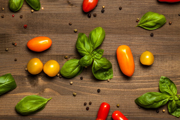Basil, pepper and cherry tomatoes composition, on dark wooden table