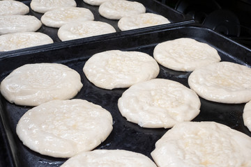 Raw cakes before baking, smeared with egg, lying on baking sheet 