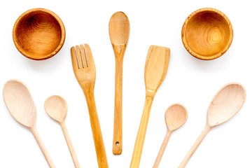 Fork, spoon, bowl in woodenware set on white background top view