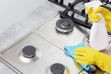Cleaning a gas stove with kitchen utensils, household concepts, or hygiene and cleaning.