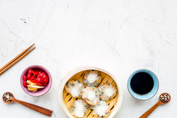 Chinese food set with dim sum, sticks and tea on marble background top view copy space