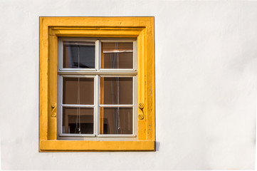 Fenster eines restaurierten Fachwerkhauses teils verputzt mit Sandsteinumrahmnung, verziert und gelber Fasche