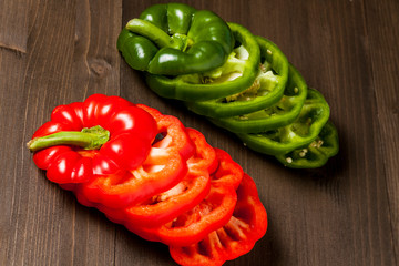 Fresh bell pepper slices isolated on wooden cutting board