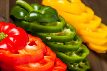 Fresh bell pepper slices isolated on wooden cutting board