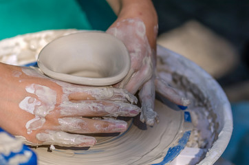 Hands working on pottery wheel
