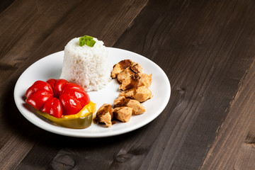 Chinese food on a white plate with rice, paprika and chicken 