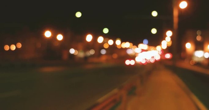Cars on overpass in nighttime defocused footage.