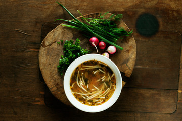 Fresh chicken soup on wooden table, top view