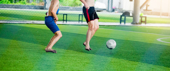 Soccer players not wearing a sport shirt and barefoot do trap and control the ball for shoot to goal