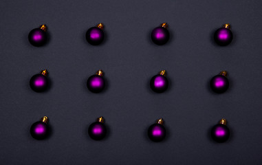 Christmas or New Year background with violet balls on black background. 