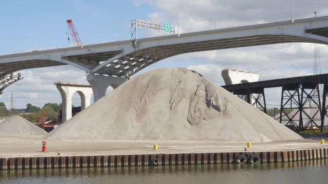 Giant pile of gravel. Scranton Flats, Cleveland, Ohio, USA. Innerbelt Bridge and freeway (Interstate 90) in the background.