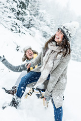 Fototapeta na wymiar two young people sliding on a sled