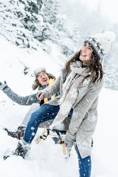 two young people sliding on a sled