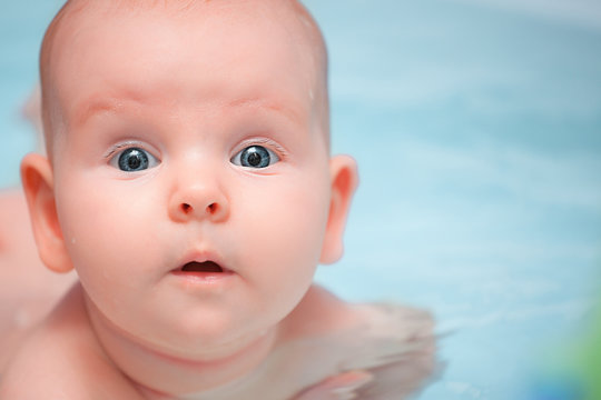 surprised baby swimming in the bath