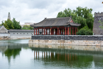 Pavilion on the north east corner of The Forbidden City, showing reflections in the surrounding tongzi river, Beijing, China.