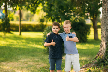 Obraz premium Two bothers spend time in park. They have fun and some relax befour school