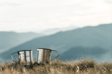 metal cups on a background of mountains