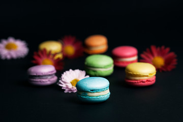 Sweet and colourful french macaroons on black background.