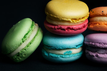 Pile of macaroons on black background.