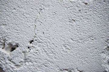 Painted wall with grungy texture closeup photo. White plaster brushed texture. White concrete wall.