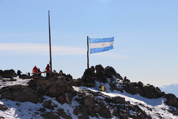 Bandera Argentina flameando en la cima nevada del Cerro Catedral en San Carlos de Bariloche Patagonia con nieve